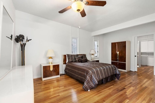 bedroom featuring ceiling fan, baseboards, and light wood-style flooring