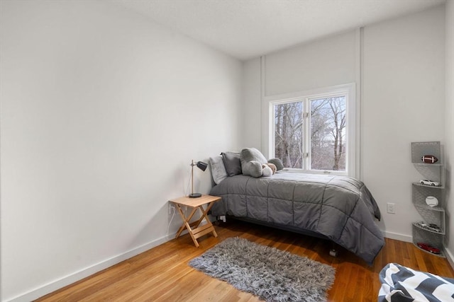 bedroom with baseboards and wood finished floors