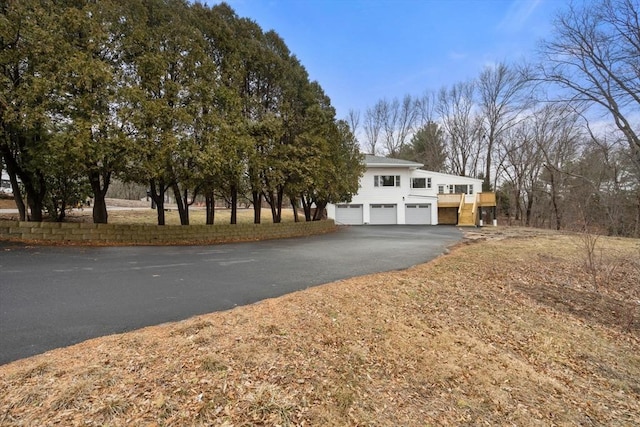 view of front facade with aphalt driveway and a garage