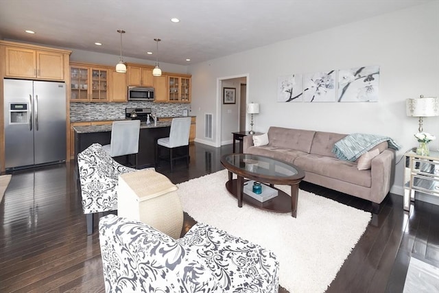 living area with visible vents, dark wood-style flooring, and recessed lighting