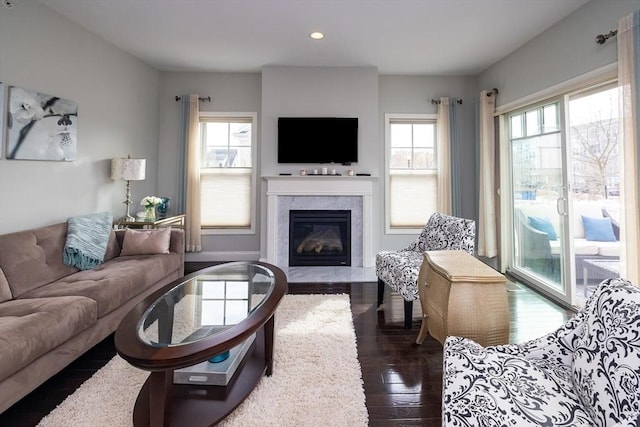 living area featuring recessed lighting, a fireplace, and dark wood finished floors