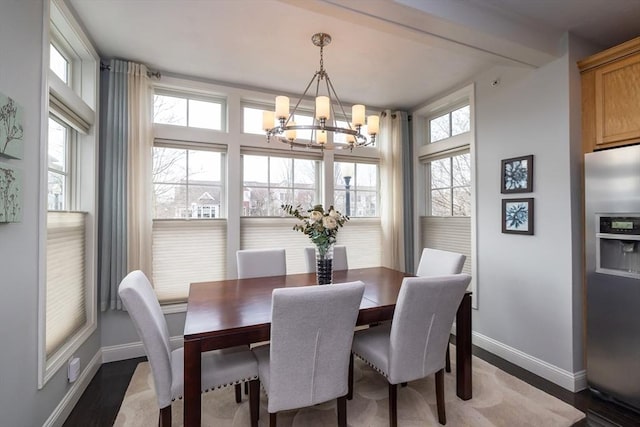 dining room featuring dark wood-style flooring, baseboards, and an inviting chandelier