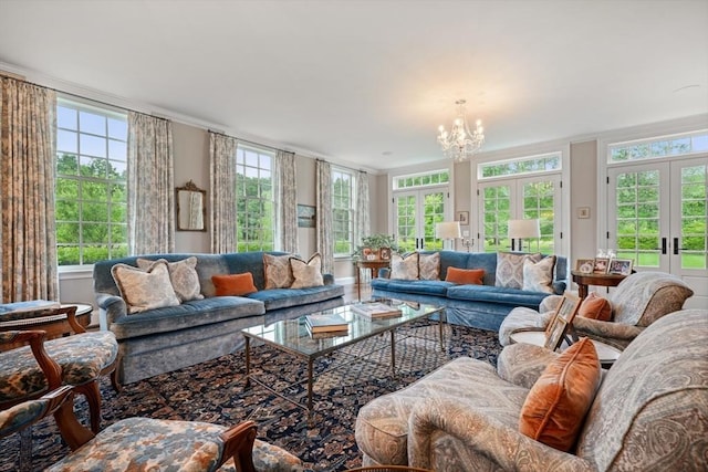 living room featuring ornamental molding, a healthy amount of sunlight, a chandelier, and french doors