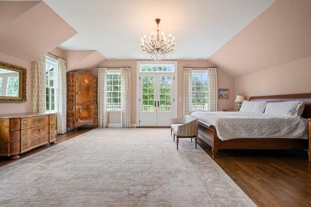 bedroom featuring vaulted ceiling, dark hardwood / wood-style floors, access to outside, a notable chandelier, and french doors