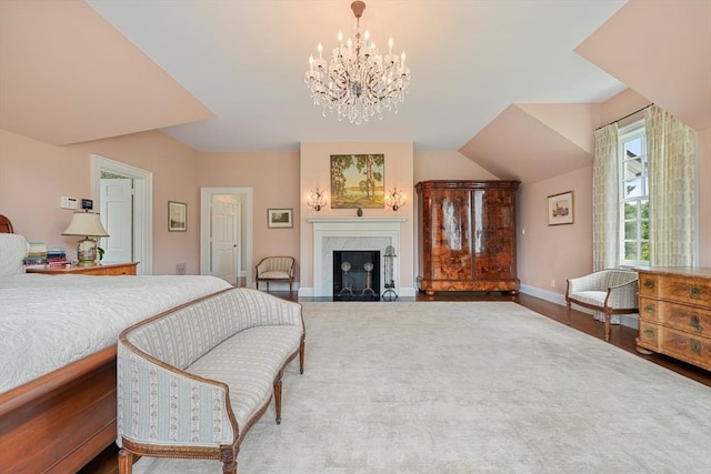 bedroom with hardwood / wood-style flooring, a fireplace, and a chandelier