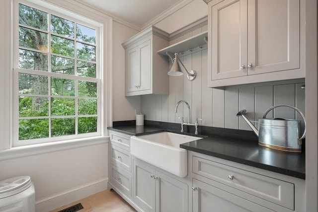 kitchen featuring sink, light tile patterned floors, ornamental molding, decorative backsplash, and white cabinets