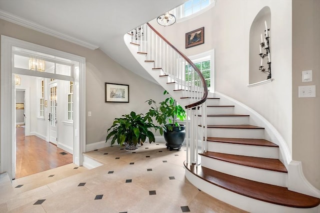 stairway with tile patterned flooring and ornamental molding