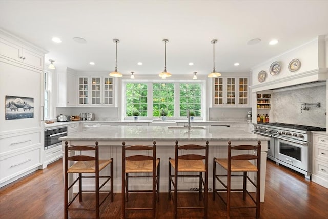 kitchen featuring stainless steel appliances, sink, a breakfast bar area, and a center island with sink