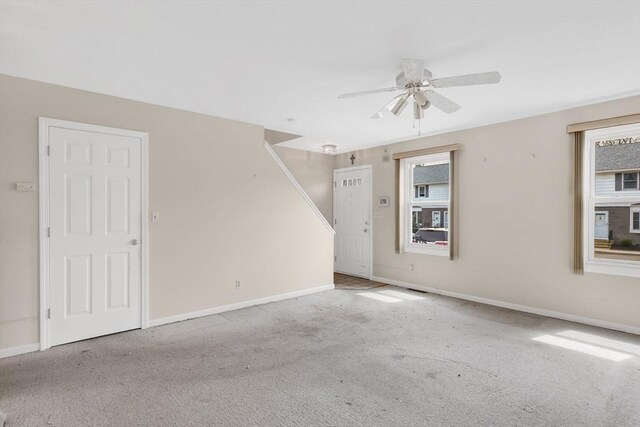 carpeted empty room with baseboards and ceiling fan