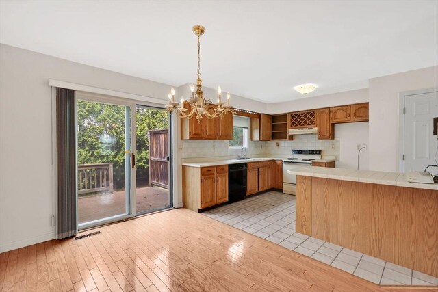 kitchen with electric range, light wood-style floors, black dishwasher, backsplash, and a notable chandelier