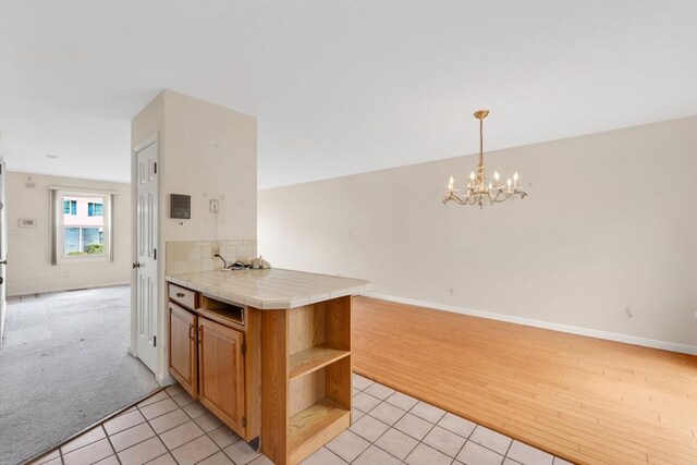 kitchen featuring open floor plan, open shelves, an inviting chandelier, and light tile patterned floors