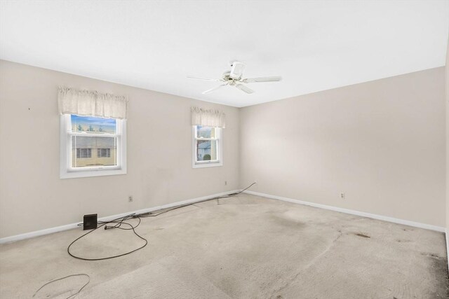 empty room with baseboards, light colored carpet, and ceiling fan