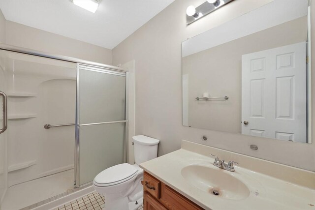 full bath with vanity, tile patterned floors, toilet, and a shower stall