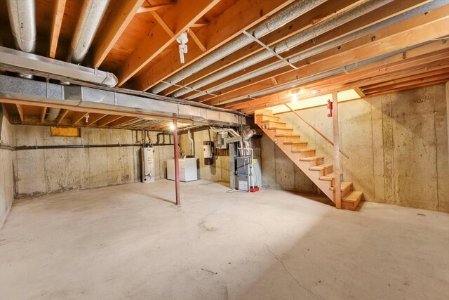 unfinished basement featuring water heater, heating unit, and stairway