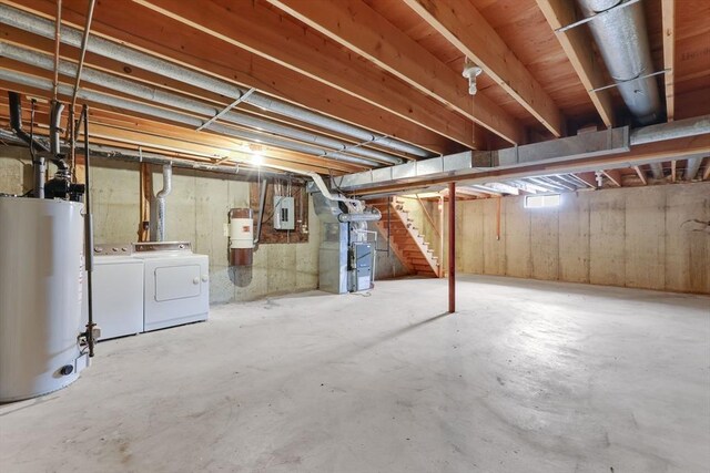 unfinished basement with washer and dryer, stairway, heating unit, and water heater