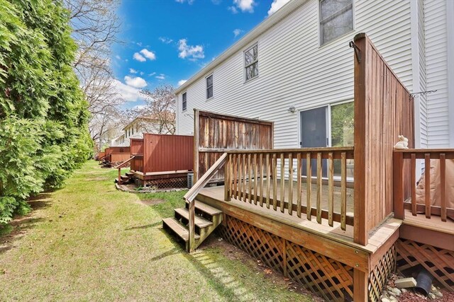 back of property featuring a lawn and a wooden deck
