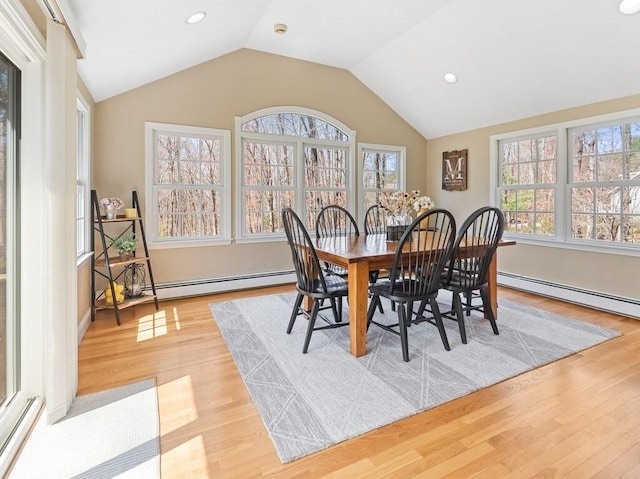 dining space with vaulted ceiling, light wood-style flooring, and baseboard heating