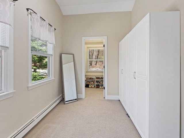 unfurnished bedroom featuring a baseboard radiator, light carpet, and multiple windows