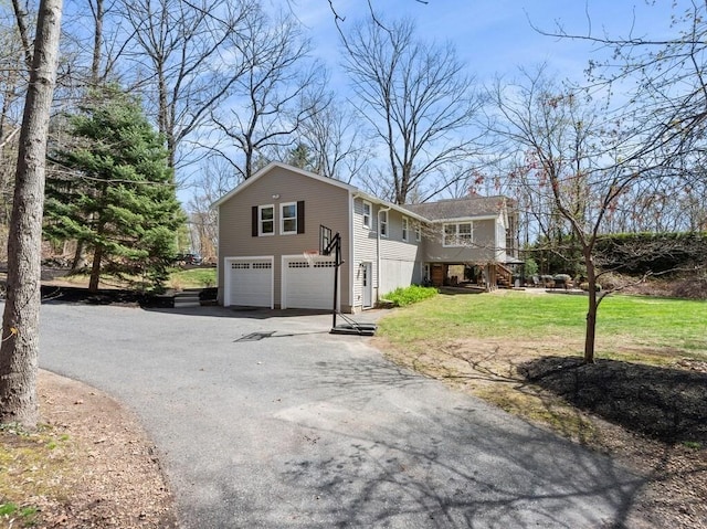 view of front of house featuring a front yard, aphalt driveway, and a garage