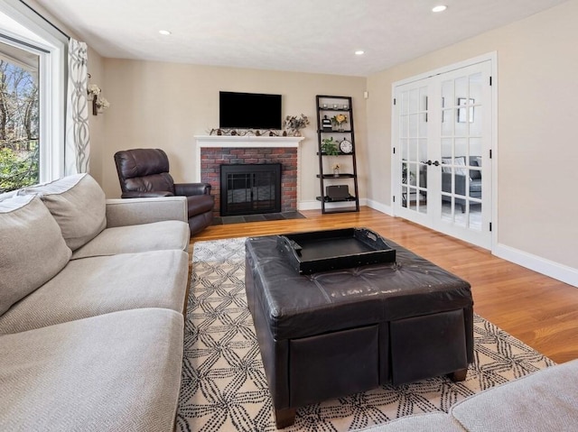 living area with a brick fireplace, wood finished floors, recessed lighting, and baseboards