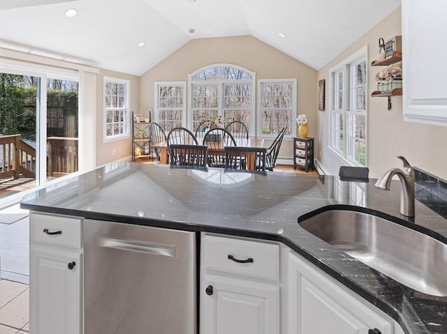 kitchen with white cabinetry, vaulted ceiling, and a sink