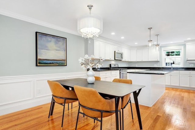 5 Allen St Unit 5, Woburn, MA 01801 - kitchen featuring appliances with stainless steel finishes, crown molding, white cabinets, a kitchen island, and light wood-style floors