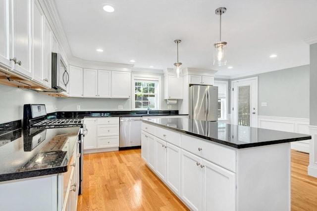 5 Allen St Unit 5, Woburn, MA 01801 - kitchen featuring appliances with stainless steel finishes, white cabinetry, light wood-type flooring, a kitchen island, and wainscoting