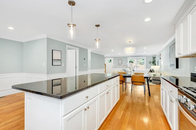 5 Allen St Unit 5, Woburn, MA 01801 - kitchen featuring ornamental molding, a kitchen island, light wood-style flooring, a wainscoted wall, and white cabinetry