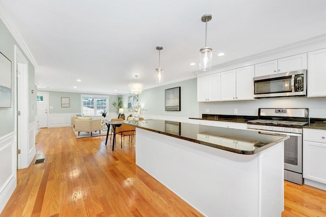 5 Allen St Unit 5, Woburn, MA 01801 - kitchen with appliances with stainless steel finishes, dark countertops, ornamental molding, white cabinets, and light wood-style floors