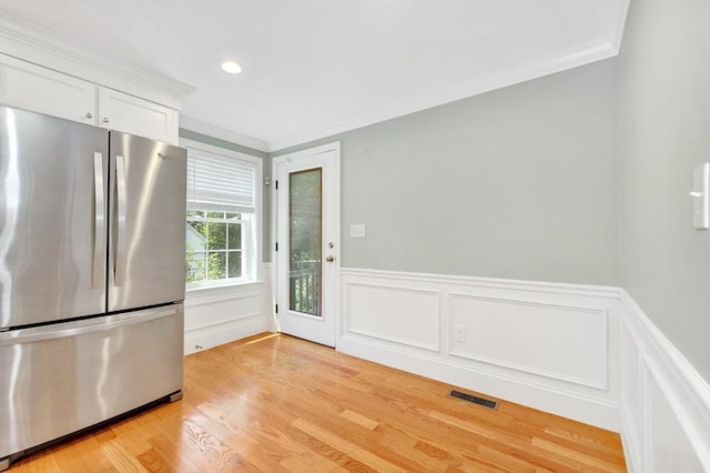5 Allen St Unit 5, Woburn, MA 01801 - kitchen with freestanding refrigerator, crown molding, light wood-style flooring, white cabinets, and a wainscoted wall