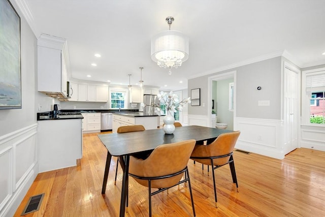 5 Allen St Unit 5, Woburn, MA 01801 - dining area with light wood-type flooring, crown molding, a chandelier, a decorative wall, and a wainscoted wall