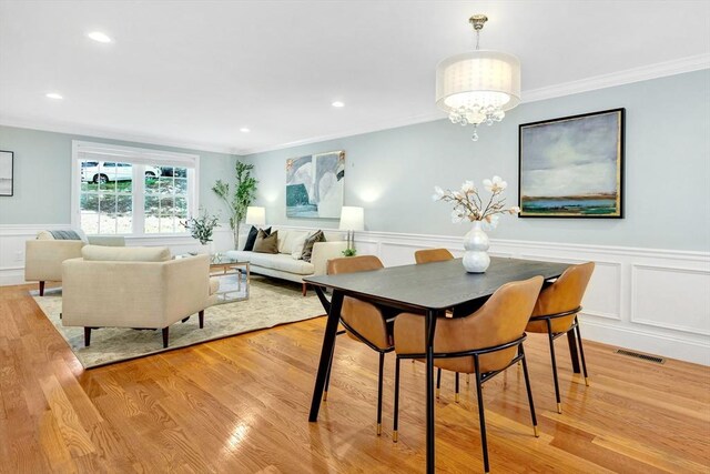 5 Allen St Unit 5, Woburn, MA 01801 - dining room featuring a decorative wall, a wainscoted wall, light wood-type flooring, crown molding, and a chandelier