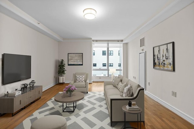 living room with a wall of windows, light wood-type flooring, and crown molding