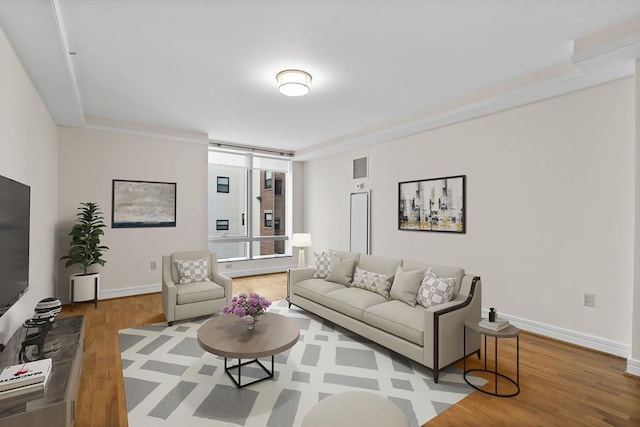 living room with hardwood / wood-style flooring and ornamental molding