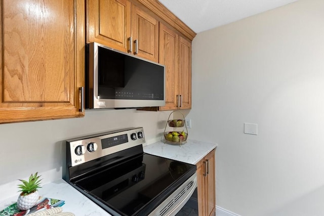 kitchen featuring light stone counters and stainless steel appliances