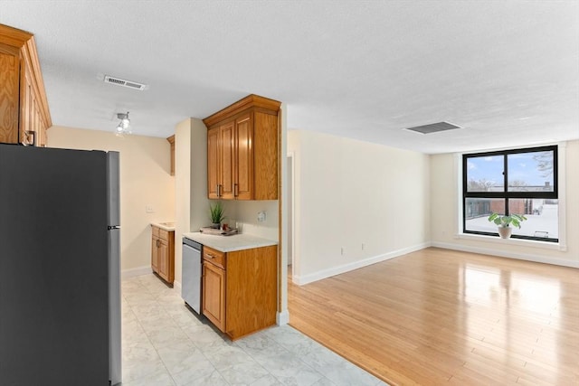 kitchen with stainless steel appliances and light hardwood / wood-style floors