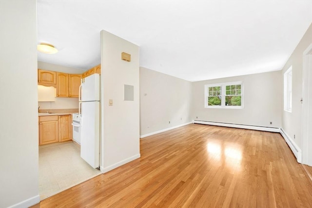 108 Emerson Gardens Rd Unit 108, Lexington, MA 02420 - unfurnished living room with a baseboard heating unit, light wood finished floors, baseboards, and a sink