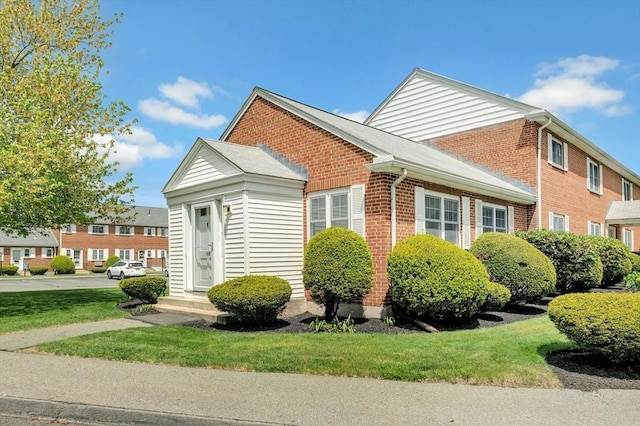108 Emerson Gardens Rd Unit 108, Lexington, MA 02420 - view of side of home featuring brick siding and a yard