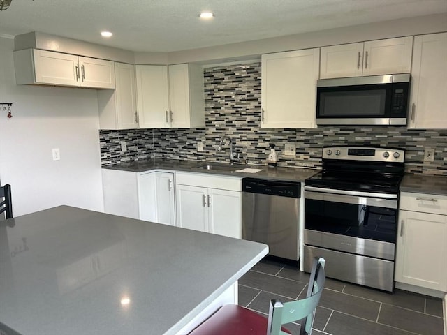 450-458 Riverside Dr Unit 2, Lawrence, MA 01841 - kitchen with stainless steel appliances, dark countertops, white cabinets, tasteful backsplash, and recessed lighting