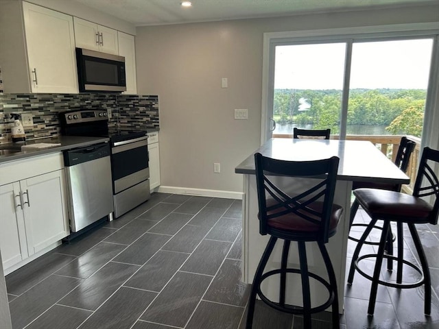 450-458 Riverside Dr Unit 2, Lawrence, MA 01841 - kitchen with stainless steel appliances, backsplash, recessed lighting, and white cabinetry