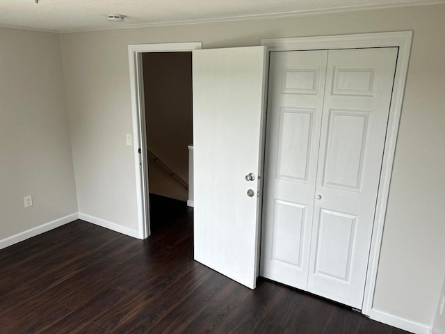 450-458 Riverside Dr Unit 2, Lawrence, MA 01841 - unfurnished bedroom with dark wood-style flooring, a closet, and crown molding