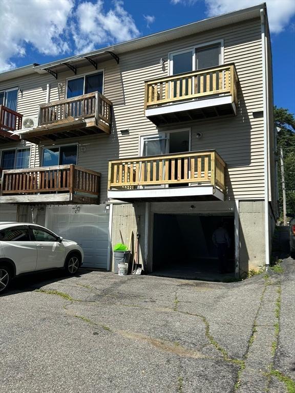 450-458 Riverside Dr Unit 2, Lawrence, MA 01841 - rear view of property featuring an attached garage and asphalt driveway