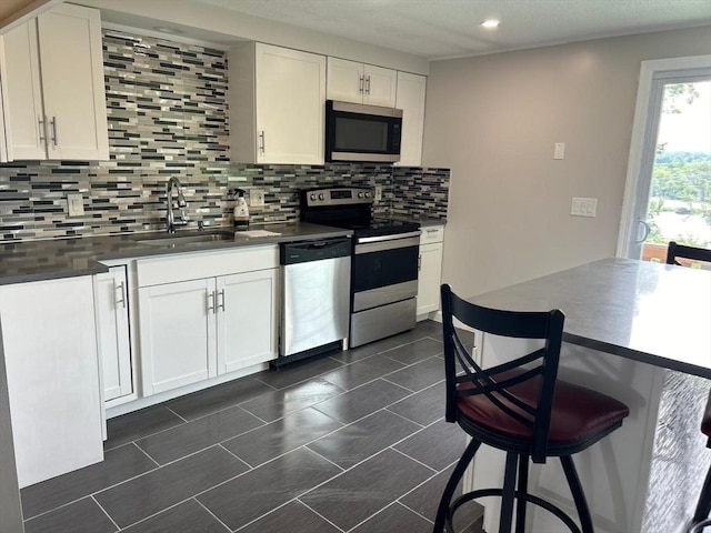 450-458 Riverside Dr Unit 2, Lawrence, MA 01841 - kitchen with appliances with stainless steel finishes, tasteful backsplash, white cabinetry, dark countertops, and recessed lighting