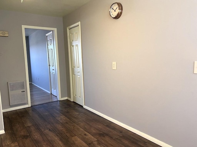 unfurnished room with dark wood-style flooring and baseboards