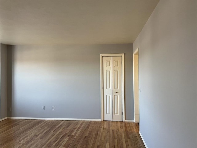 unfurnished room with baseboards and wood finished floors