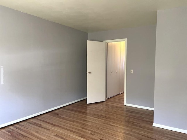 empty room with baseboards and wood finished floors