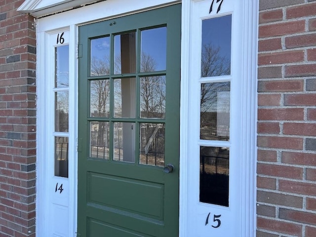 doorway to property featuring brick siding