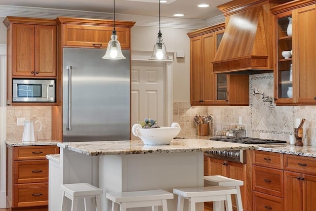 kitchen featuring custom range hood, glass insert cabinets, built in appliances, a kitchen breakfast bar, and brown cabinets