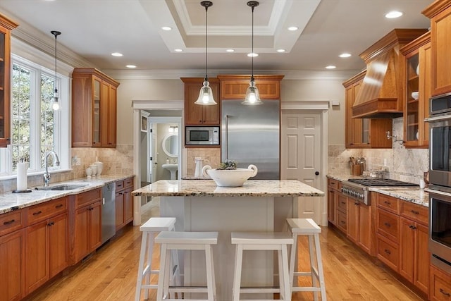 kitchen featuring crown molding, brown cabinetry, built in appliances, and a sink