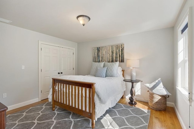 bedroom with a closet, baseboards, and wood finished floors